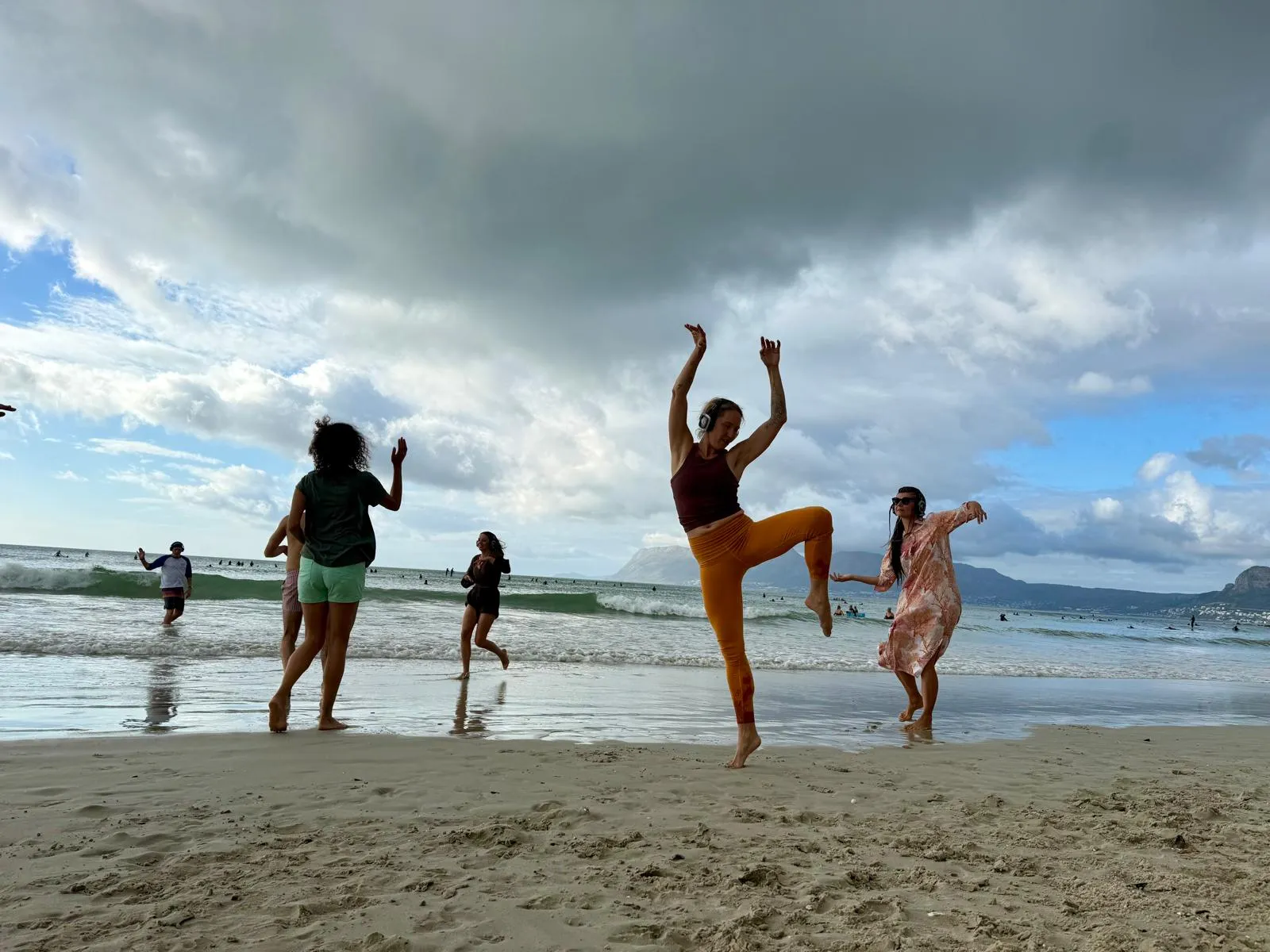 Dansere på en strand med silent disco-hovedtelefoner til en Body Choir-session