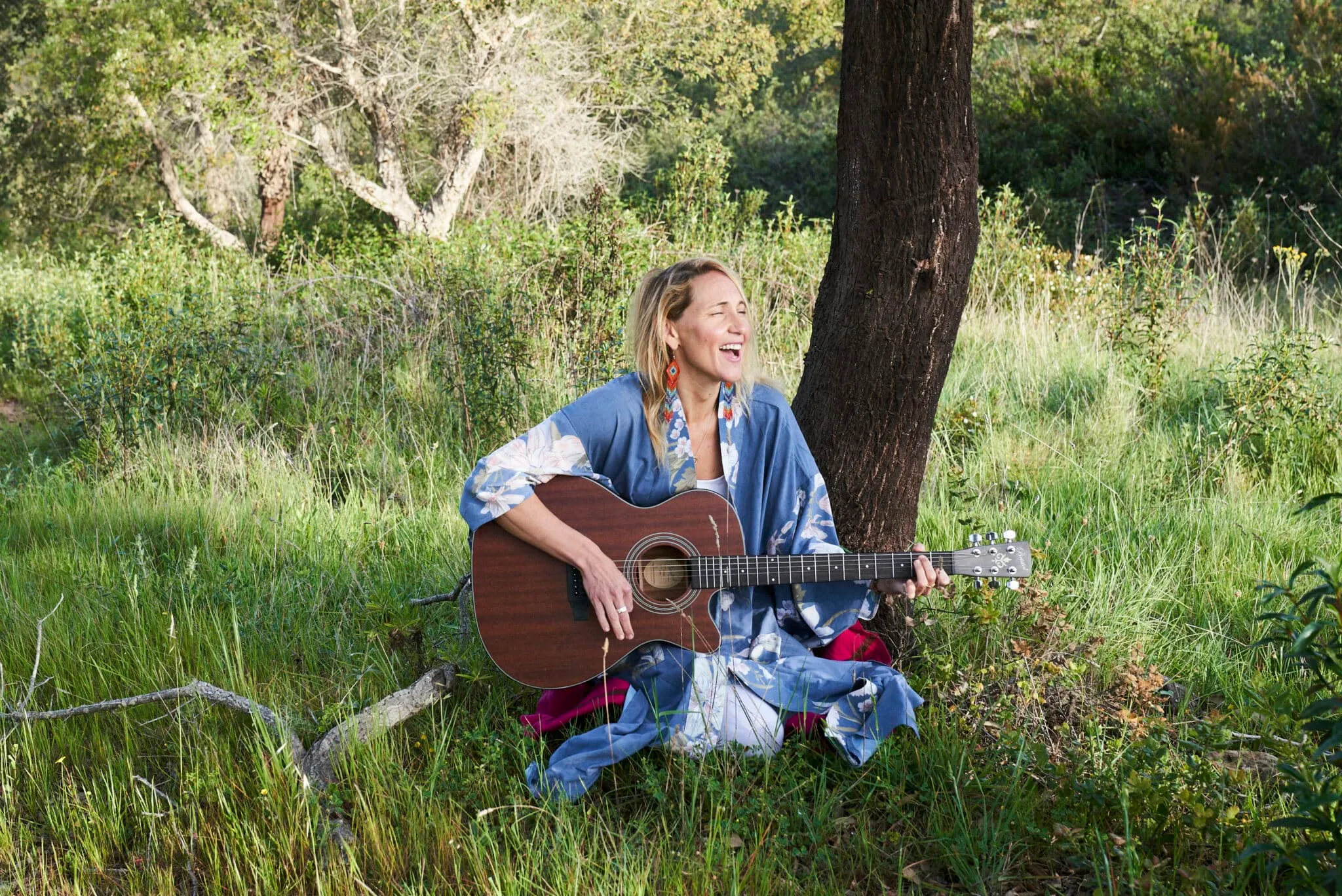 Samantha Claire playing guitar in nature